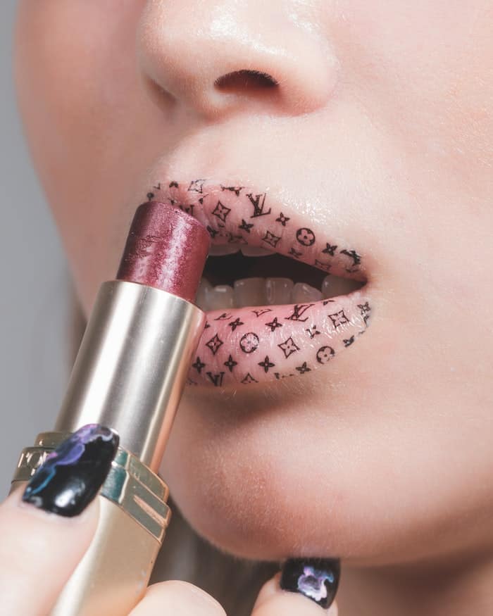 woman putting on lipstick